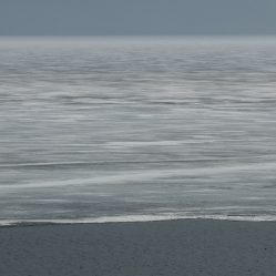 Borda do gelo do lago com a agua do rio Angara